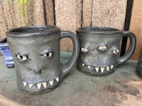 two mugs with monster faces on them