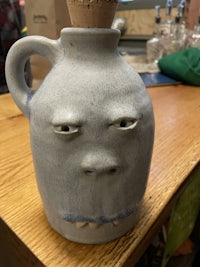 a ceramic jug with a face on it