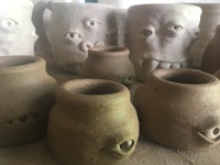 a group of clay mugs with eyes on them