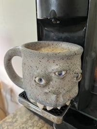 a coffee mug sitting on top of a stove