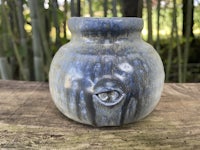 a blue vase sitting on top of a wooden table