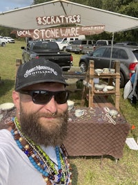 a bearded man with a beaded necklace